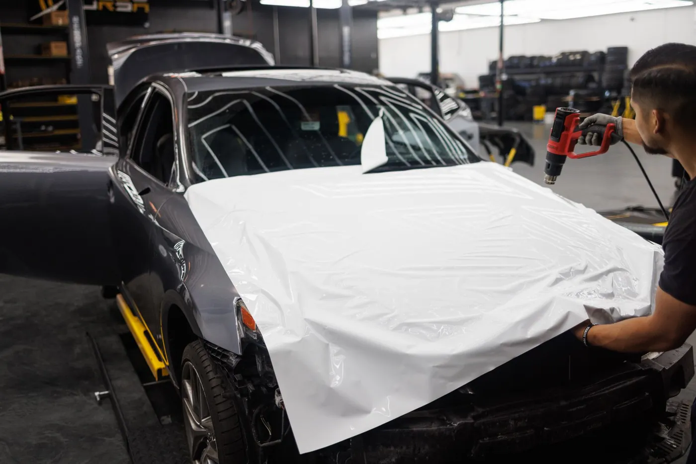 Vinyl wrap being applied to a vehicle in a workshop